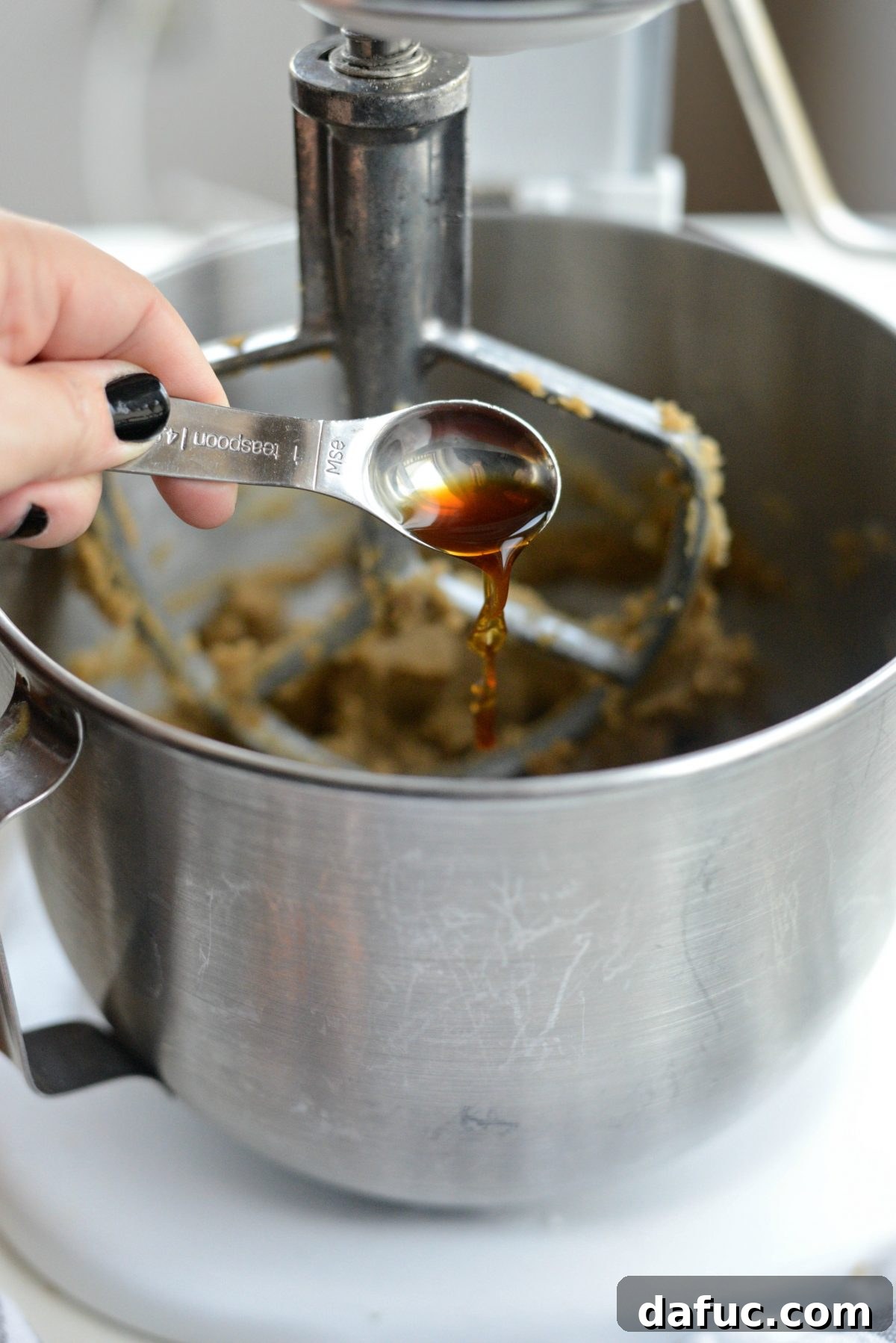 Golden Toffee Oatmeal Chocolate Chip Cookies 9 Pouring two teaspoons of pure vanilla extract into the butter and sugar mixture.