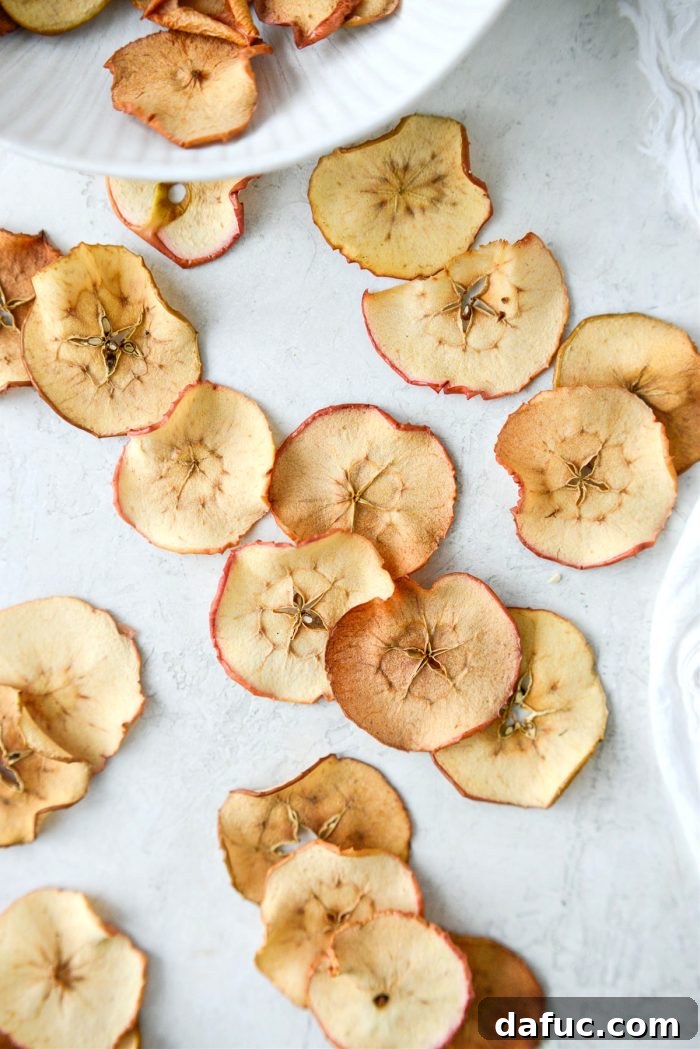 An artistic close-up of crispy baked apple chips, emphasizing their delicate texture and golden hues.