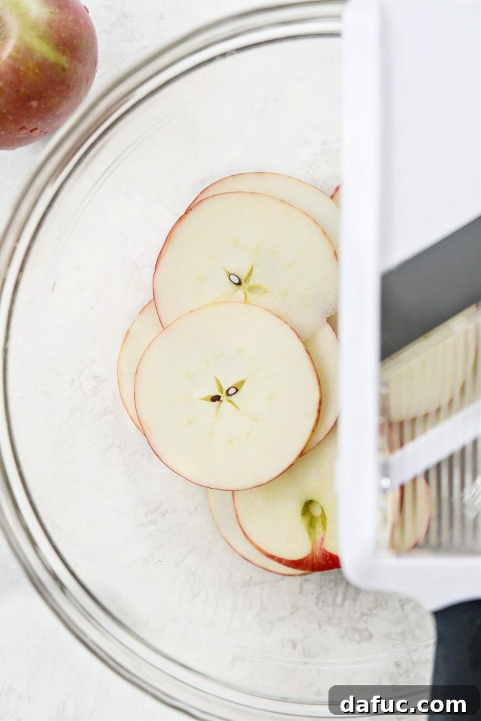 Close-up of thinly sliced apples, perfectly uniform and ready for baking into chips
