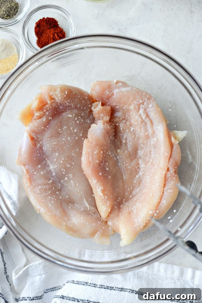 Chicken breasts seasoned with salt, resting for dry brining.