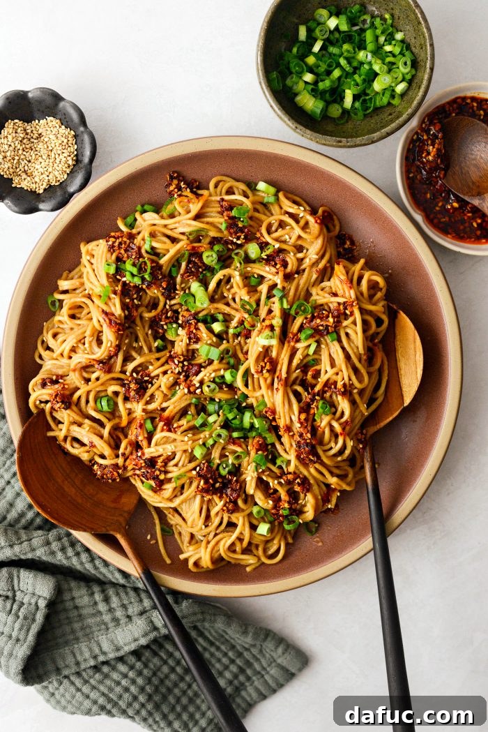 Fiery Garlic Sesame Noodles 16 A beautifully plated bowl of Spicy Garlic Sesame Noodles, artfully garnished with green onions, ready to be served.