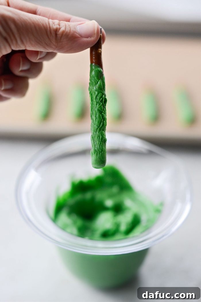 Enchanted Digits 10 Dipping a pretzel into melted green candy melts in a measuring cup