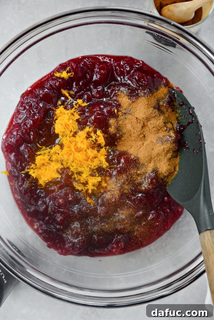 Crimson Kitchen 11 A bowl containing homemade cranberry sauce, fresh orange zest, and ground cinnamon, ready to be mixed for the filling.