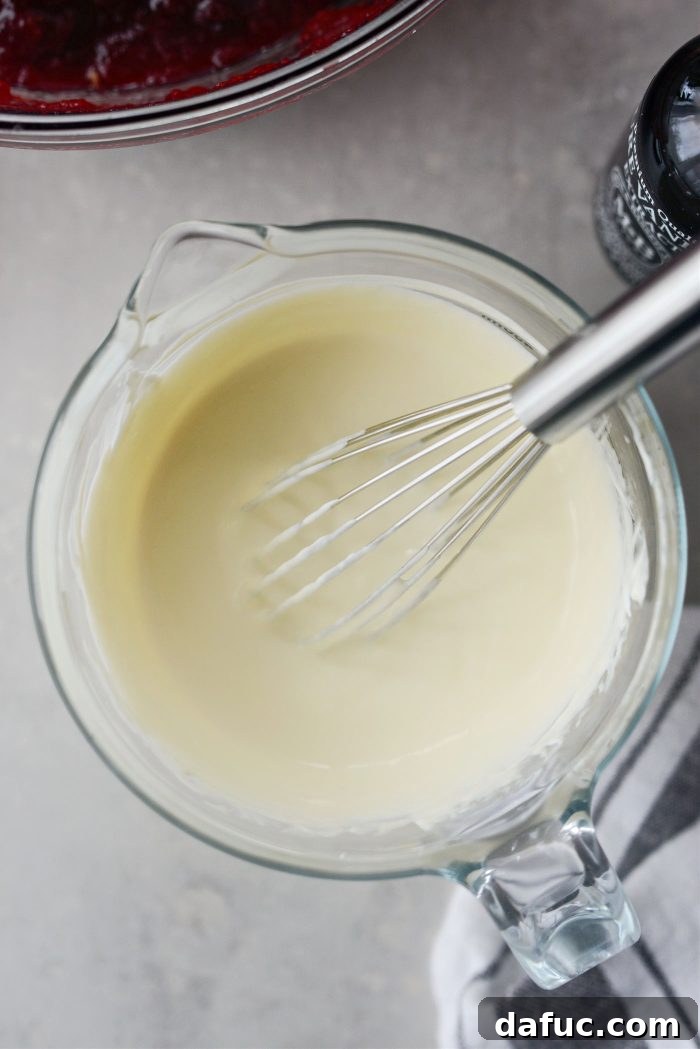 Crimson Kitchen 14 Whisking together sour cream, egg, and vanilla extract in a liquid measuring cup to create a smooth topping.