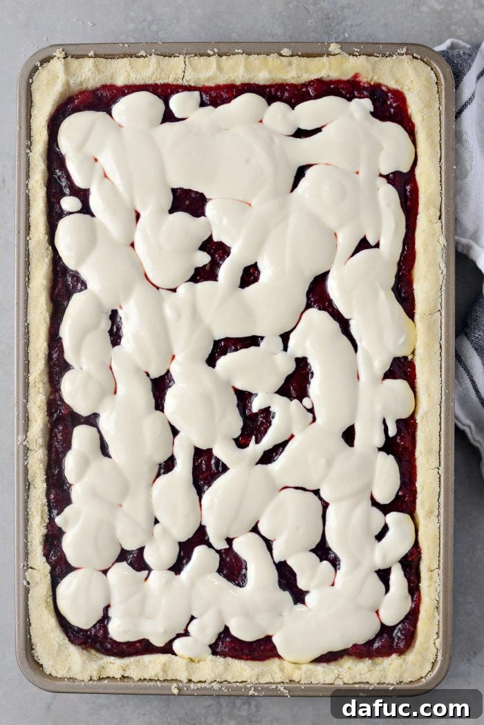 Crimson Kitchen 16 Drizzling the creamy sour cream mixture haphazardly over the cranberry filling in the pan, creating a marbled effect.