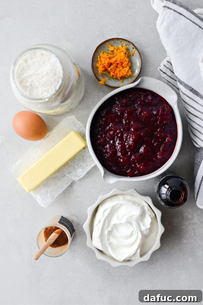 Crimson Kitchen 4 Ingredients laid out for Cranberry Küchen, including yellow cake mix, butter, cranberry sauce, orange zest, cinnamon, sour cream, egg, and vanilla extract.