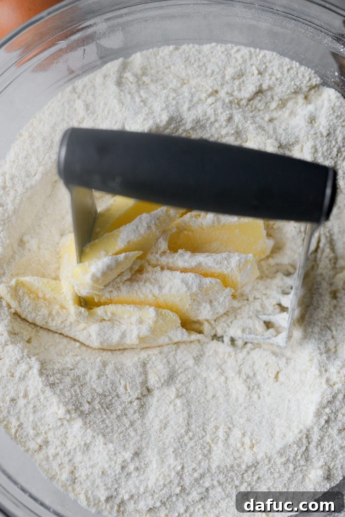 Crimson Kitchen 5 A large mixing bowl containing homemade yellow cake mix and cubes of unsalted butter, ready to be blended for the crust.