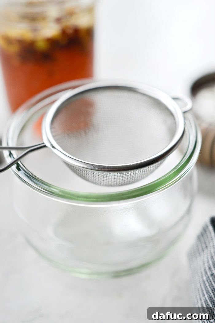 Sweet Heat Garlic Honey 12 Setting a sieve over a clean jar for straining