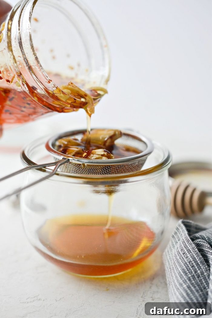 Sweet Heat Garlic Honey 13 Pouring infused honey through a strainer