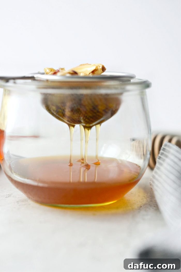 Sweet Heat Garlic Honey 14 Infused honey draining through a sieve