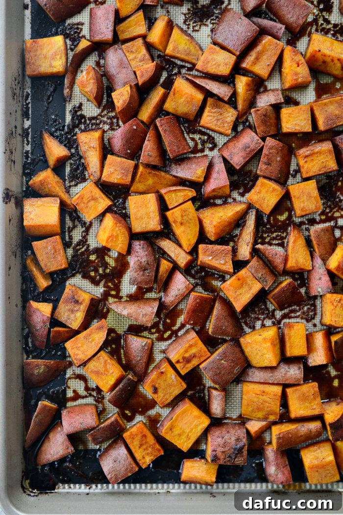 Golden-brown roasted sweet potatoes fresh out of the oven, still on the baking sheet