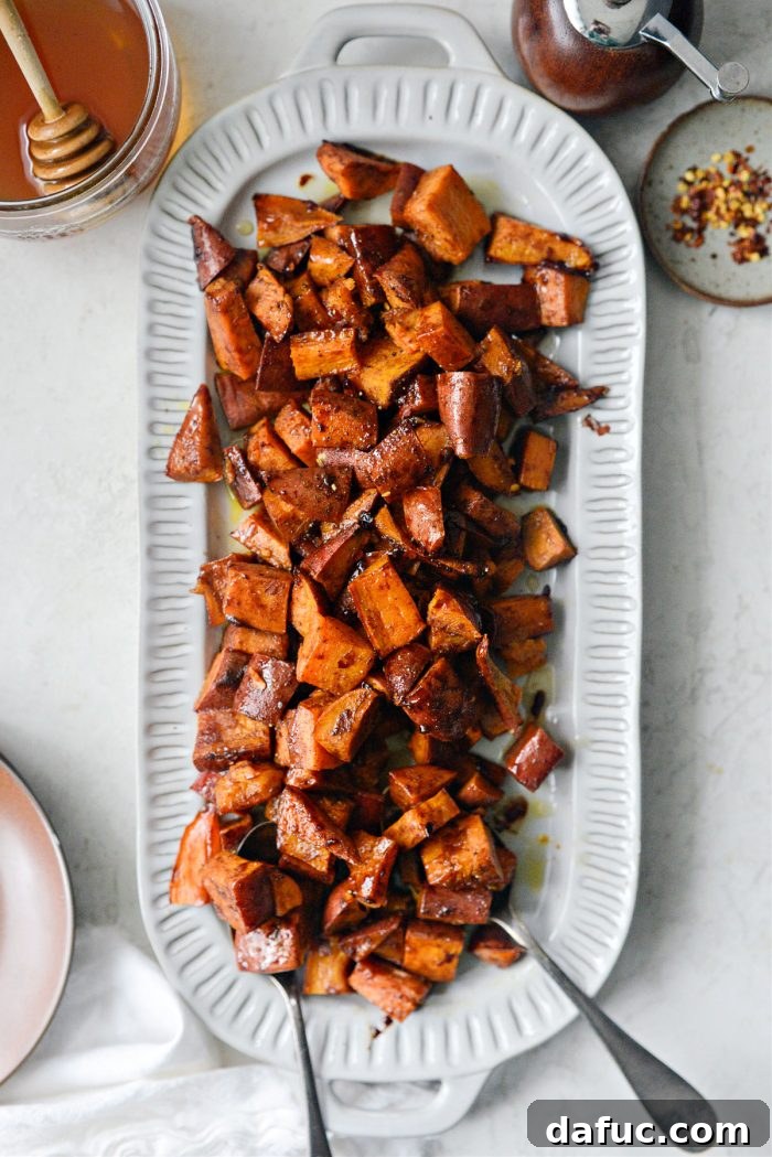 Cinnamon Roasted Hot Honey Sweet Potatoes attractively piled on a white serving platter