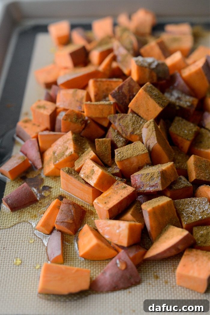 Sweet potatoes being seasoned with ground cinnamon, nutmeg, and fine salt
