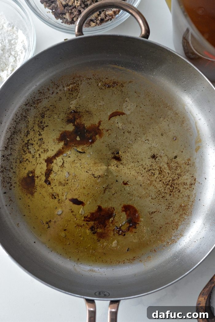 Turkey drippings separated from stock, alongside giblet stock in measuring cups
