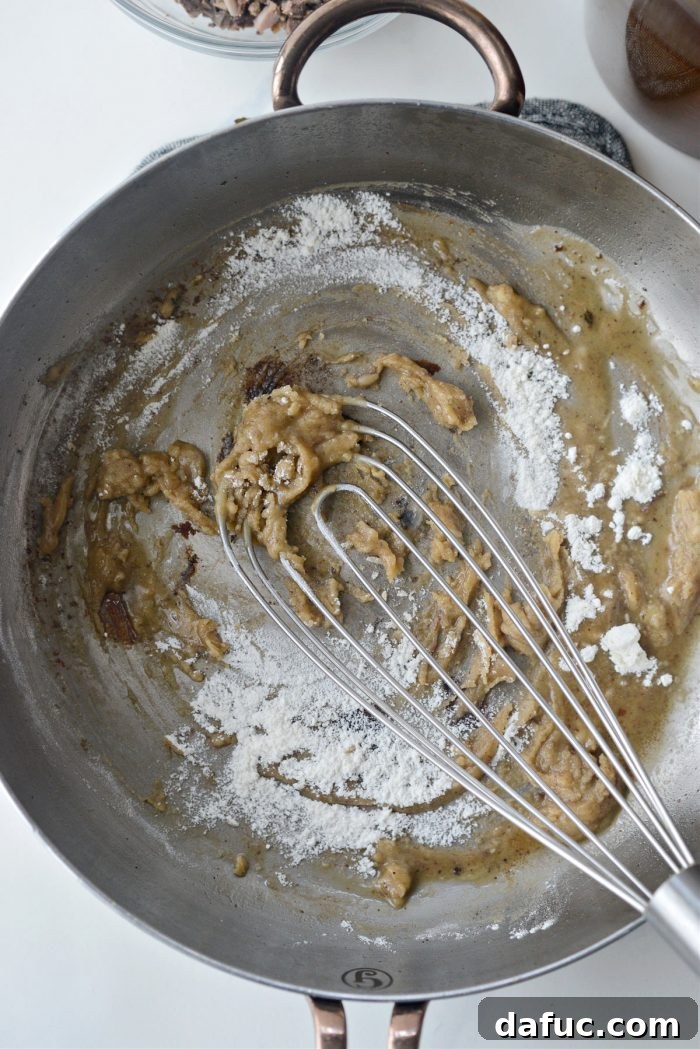Adding flour to the hot turkey drippings in a skillet to form a roux