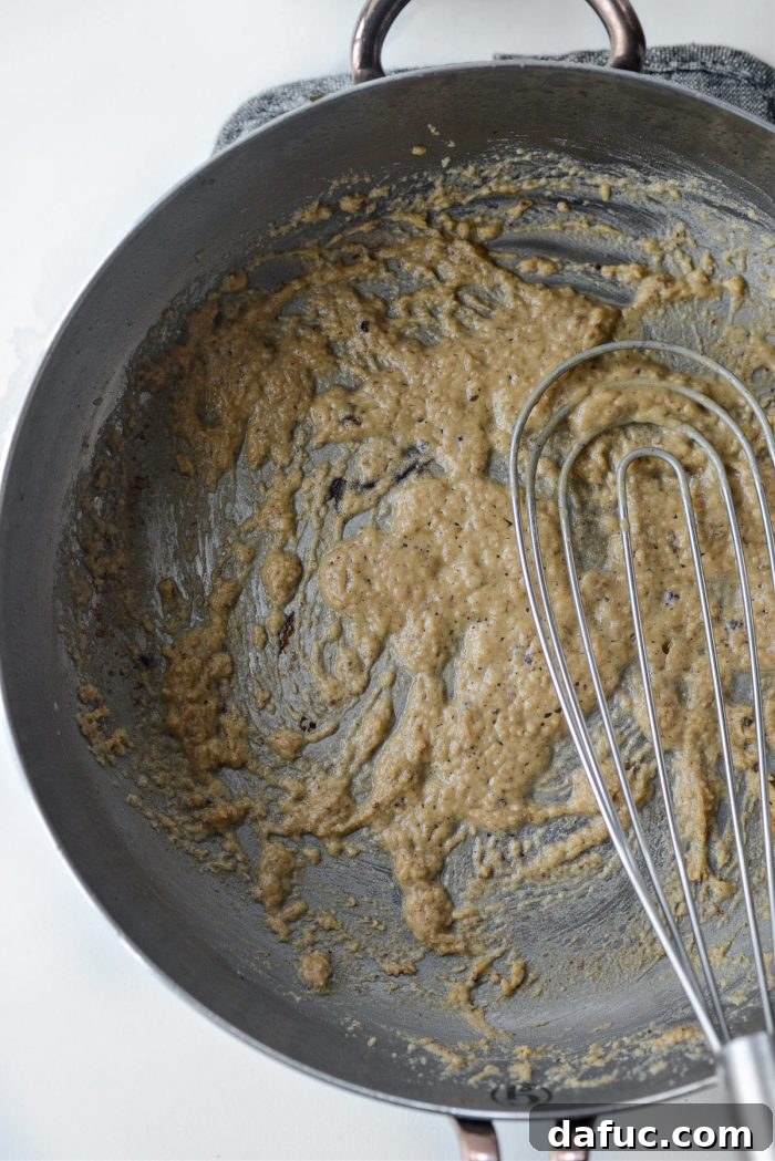 Whisking flour into turkey drippings to create a smooth, golden roux for gravy