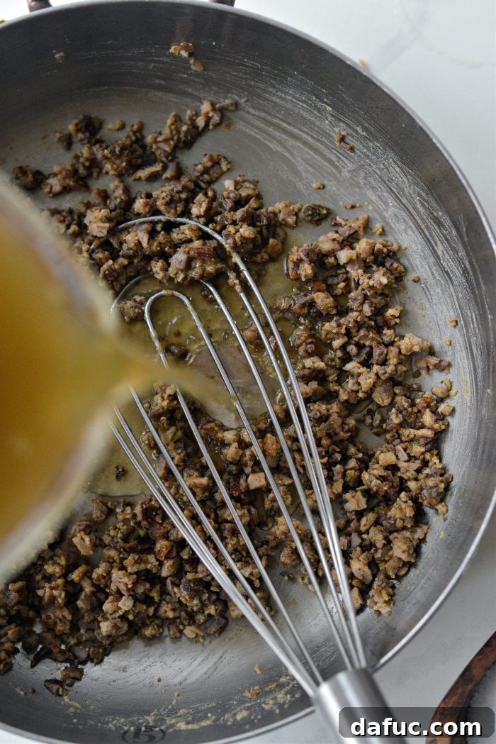 Stirring minced giblets into the rich roux, infusing the gravy with flavor