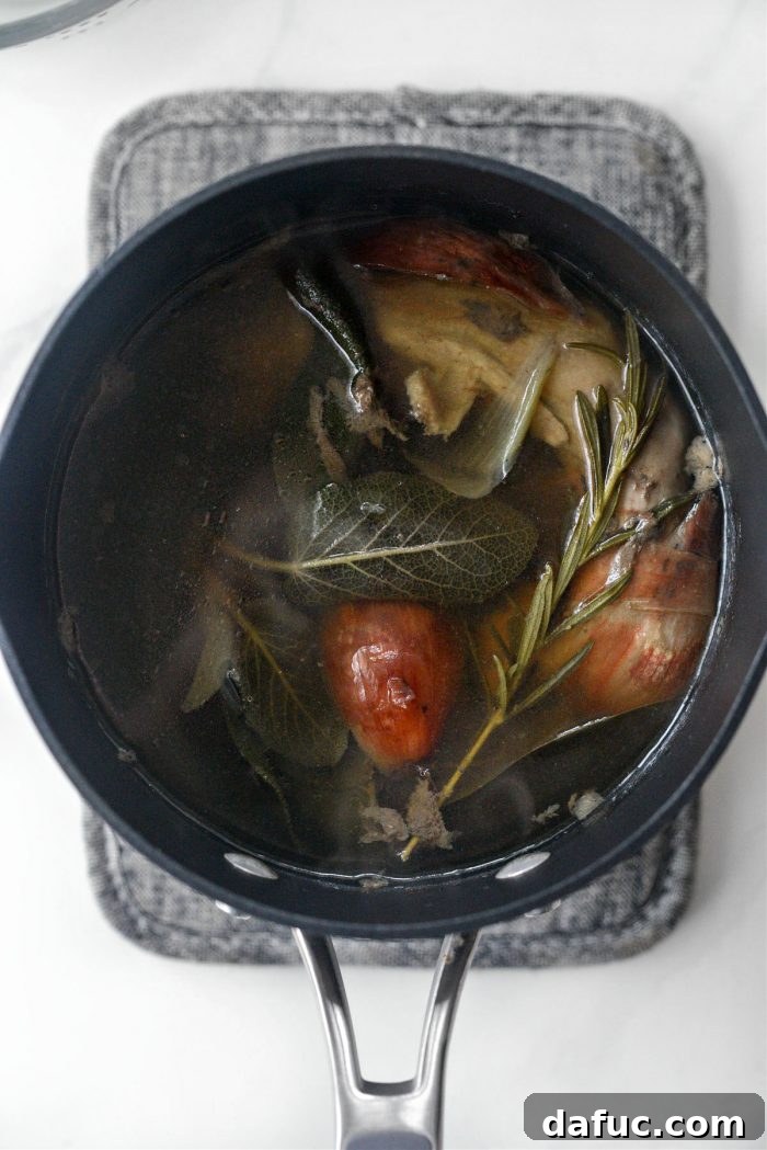 Giblet stock gently simmering on the stovetop, releasing its rich aromas