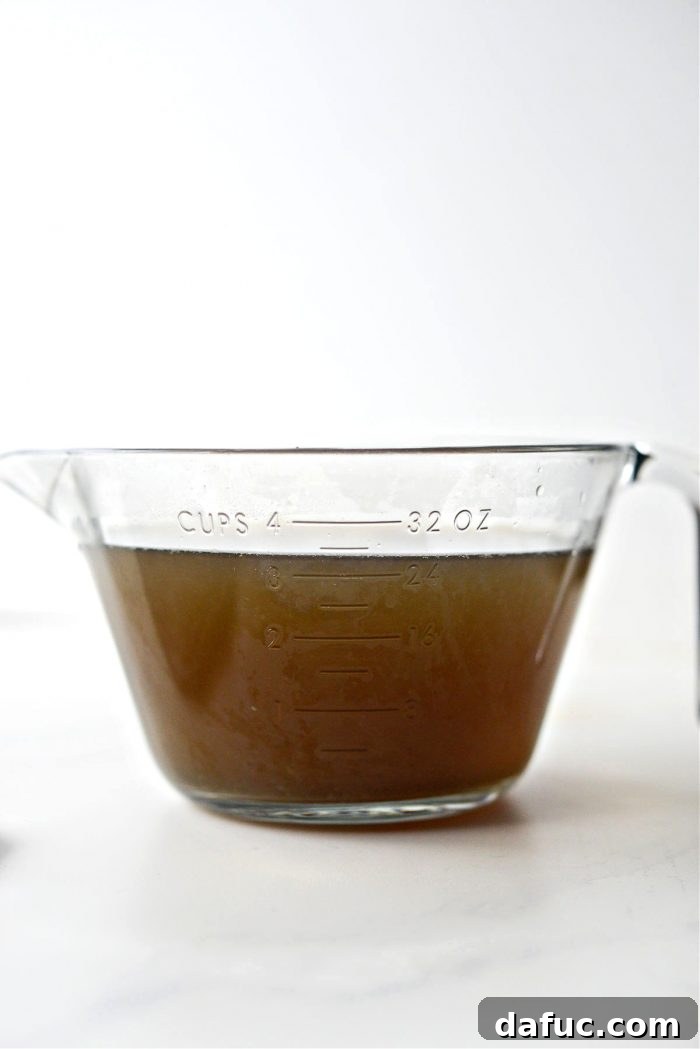 Finished, clear giblet stock in a liquid measuring cup, ready for gravy