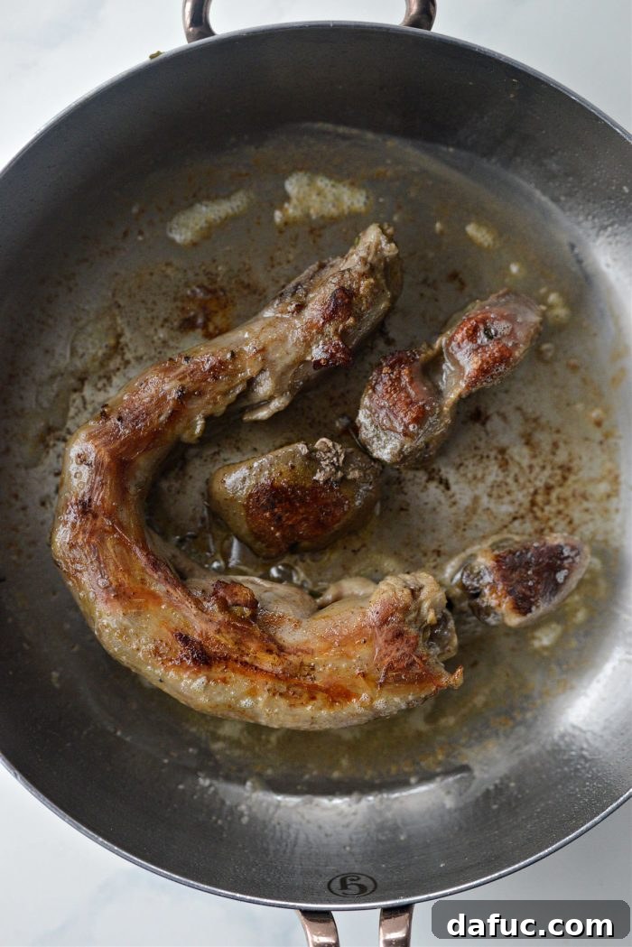 Searing turkey neck and giblets in a hot skillet with butter