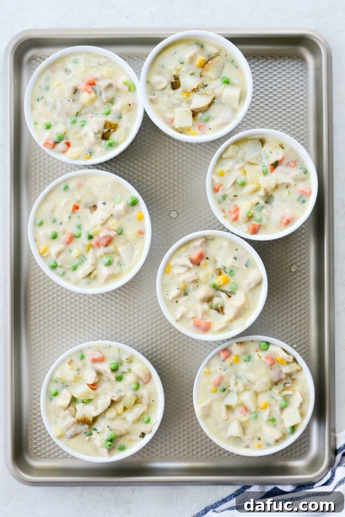 Additional diced potatoes added to the top of the pot pie filling in ramekins before crust.
