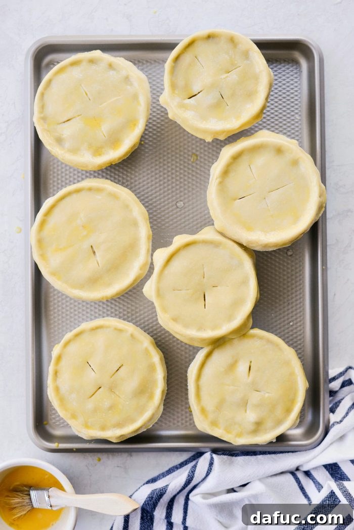 Individual chicken pot pies baking in the oven, crusts turning golden.