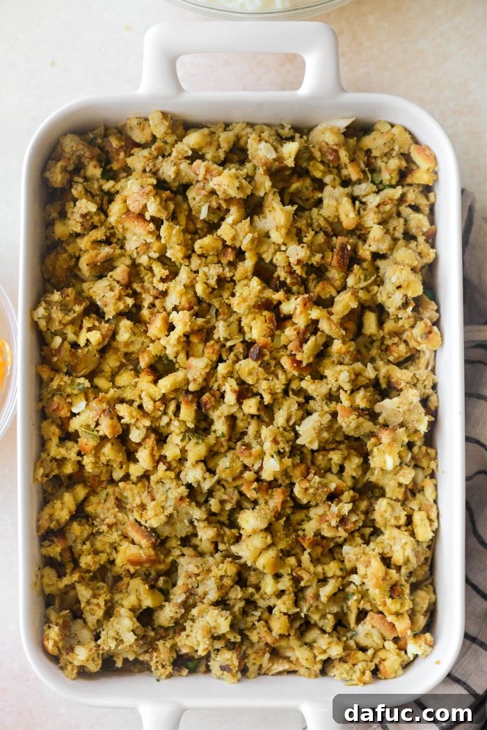 Topping the turkey filling with a generous layer of leftover stuffing