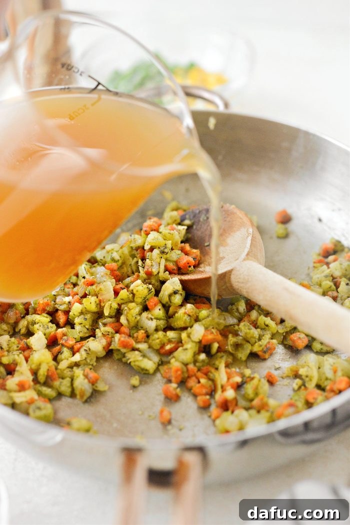 Pouring turkey stock into the skillet, stirring to combine for the shepherd's pie filling