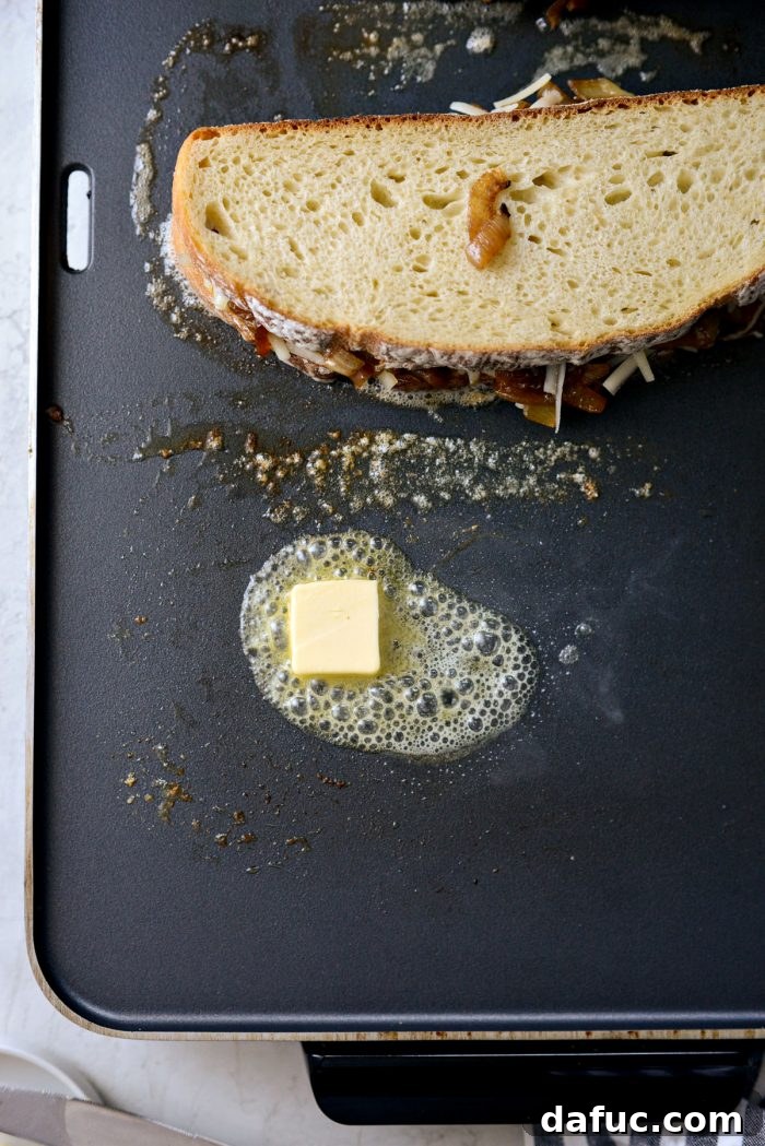 Adding more butter to griddle before flipping sandwich
