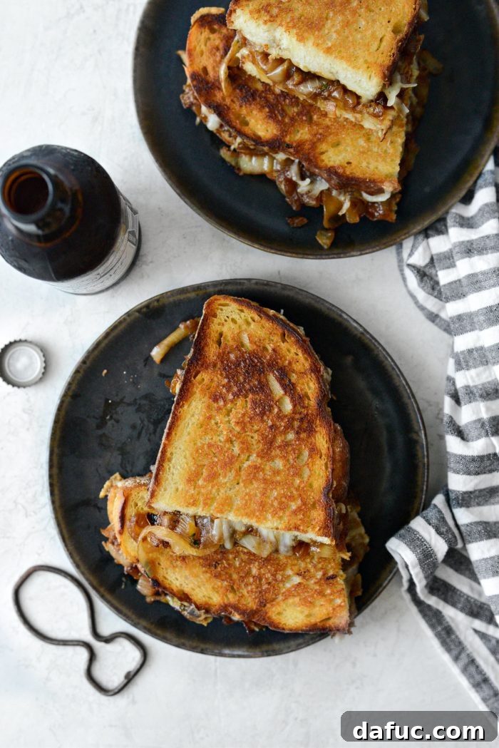 Two halves of French Onion Soup Grilled Cheese Sandwich, showing the melted cheese and filling