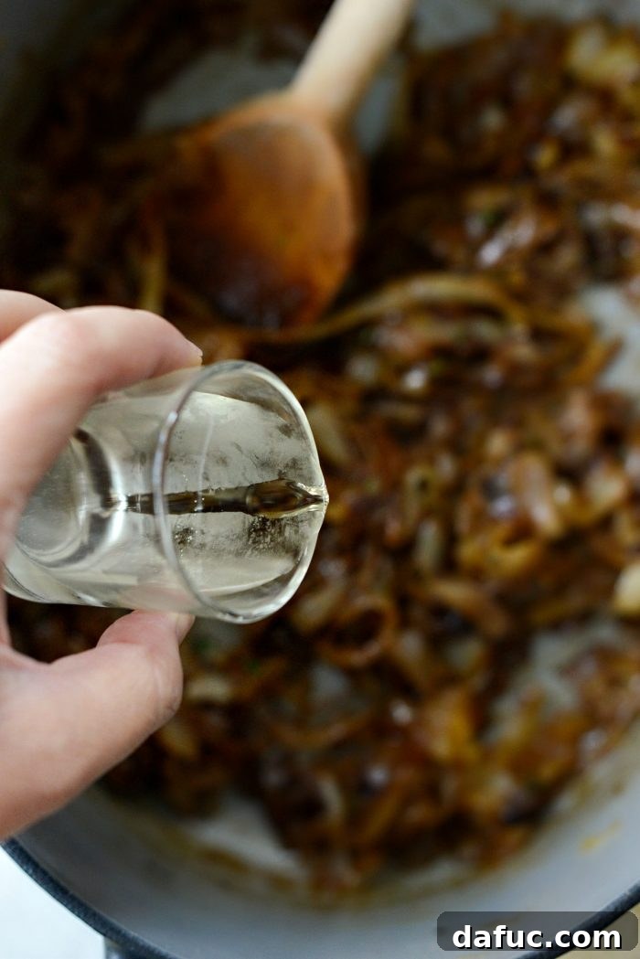 White wine being poured into caramelized onions