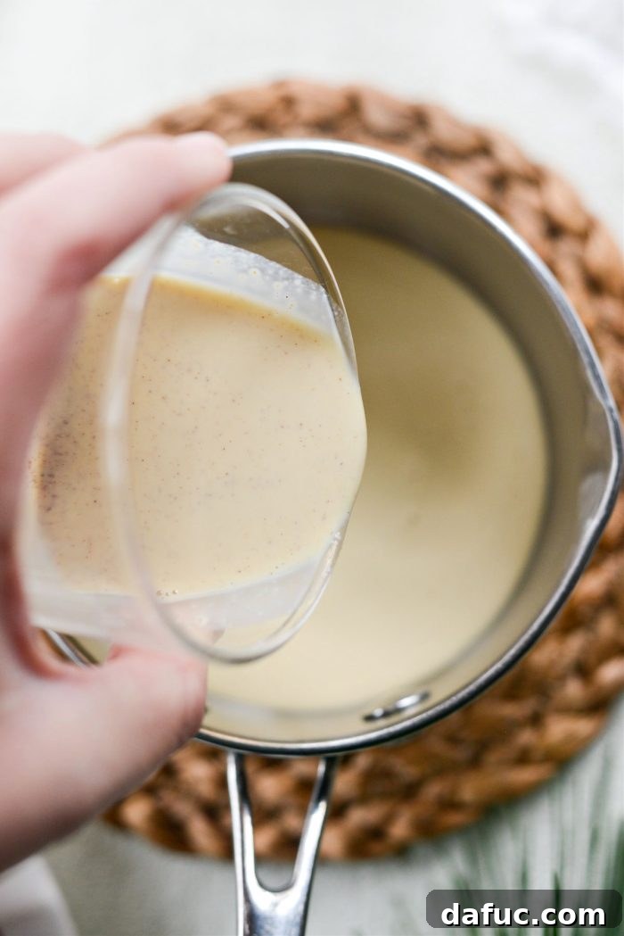 Pouring eggnog into a small saucepan