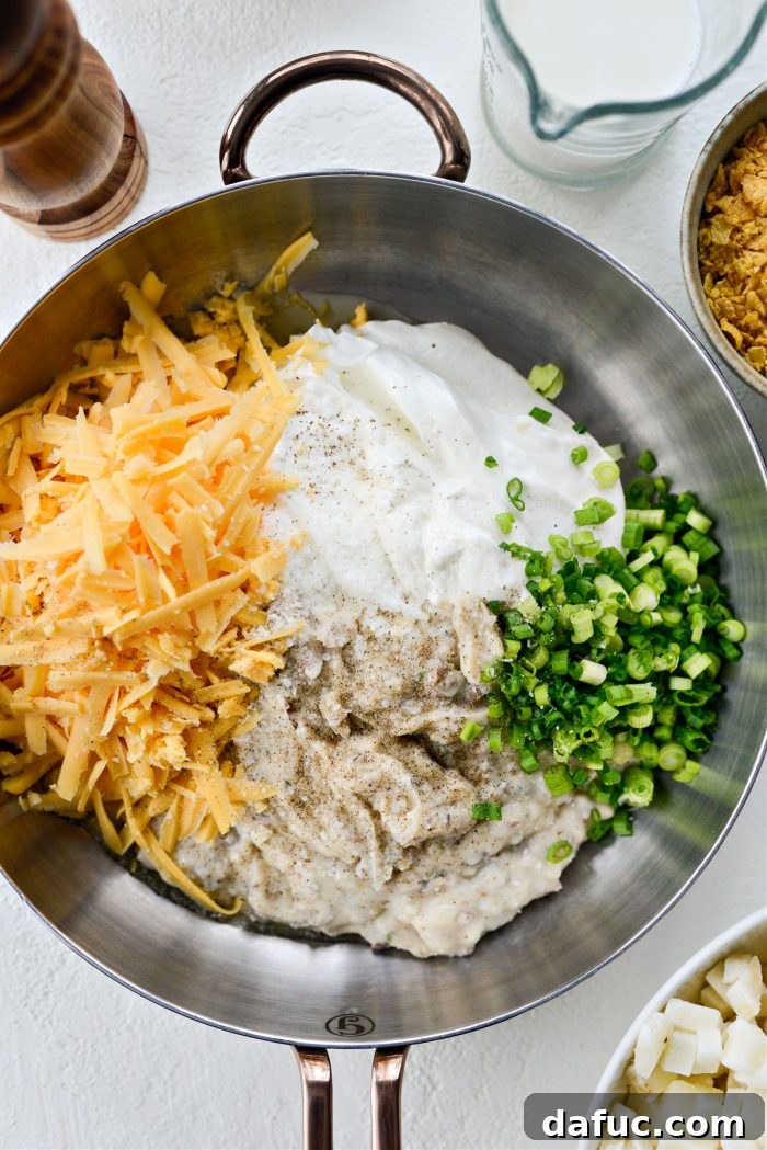 Mel's Ultimate Cheesy Potato Bake 6 Sour cream, homemade condensed cream of mushroom soup, green onions, sharp cheddar cheese, salt, and pepper, ready to be combined.