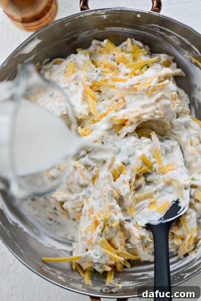 Mel's Ultimate Cheesy Potato Bake 8 Adding milk to the potato mixture for the perfect creamy consistency.