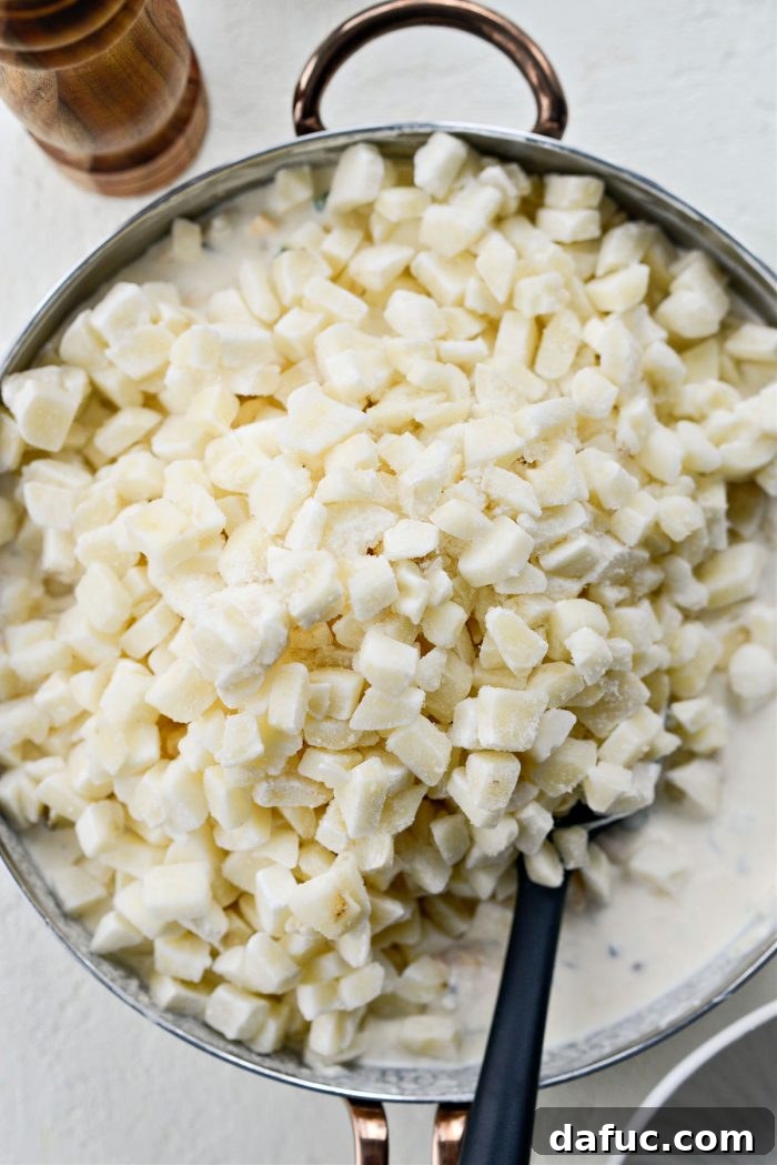 Mel's Ultimate Cheesy Potato Bake 10 Adding frozen diced hash browns to the creamy cheese mixture.