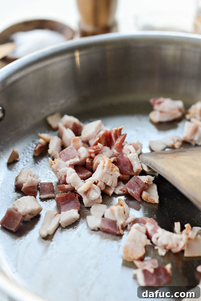 Decadent Maple Bourbon Bacon Brussels 5 Diced thick-cut bacon starting to cook in a hot skillet sprayed with olive oil.