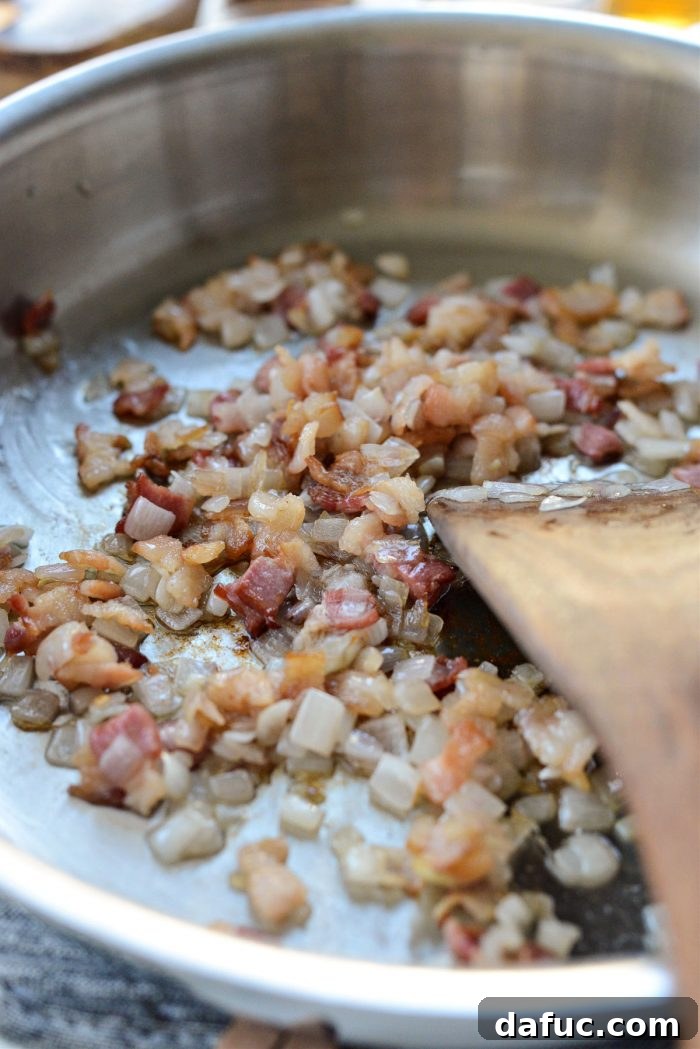 Decadent Maple Bourbon Bacon Brussels 7 Bacon and shallots cooked until crispy and tender, respectively, in a skillet.