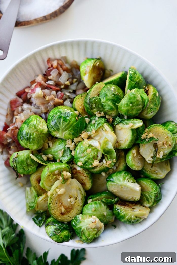 Decadent Maple Bourbon Bacon Brussels 10 Cooked Brussels sprouts being transferred to a bowl with bacon and shallots.