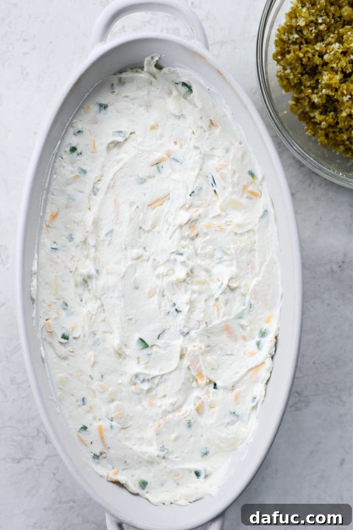 The Ultimate Jalapeño Popper Dip 11 Spreading the jalapeño dip mixture evenly in the baking dish with a spatula