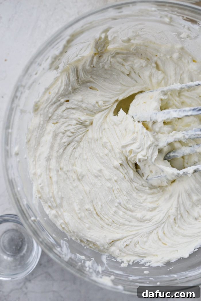 The Ultimate Jalapeño Popper Dip 6 Hand mixer blending cream cheese mixture until smooth and creamy