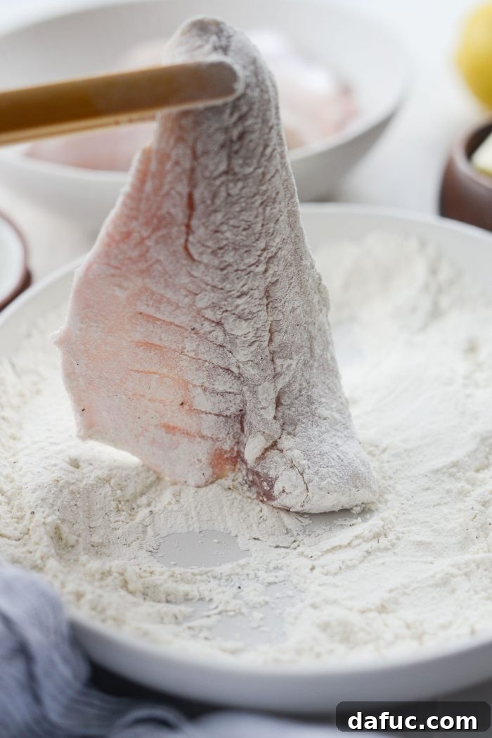 Lemon Brightened Brown Butter Perch 9 A hand gently shaking excess flour from a fish fillet