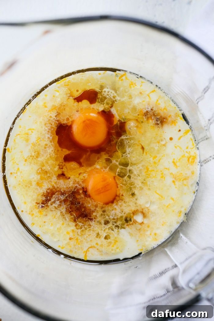 Fragrant Orange Cardamom Gems 11 Bowl with wet ingredients for muffins: orange sugar, brown sugar, eggs, olive oil, milk, orange juice, and vanilla extract