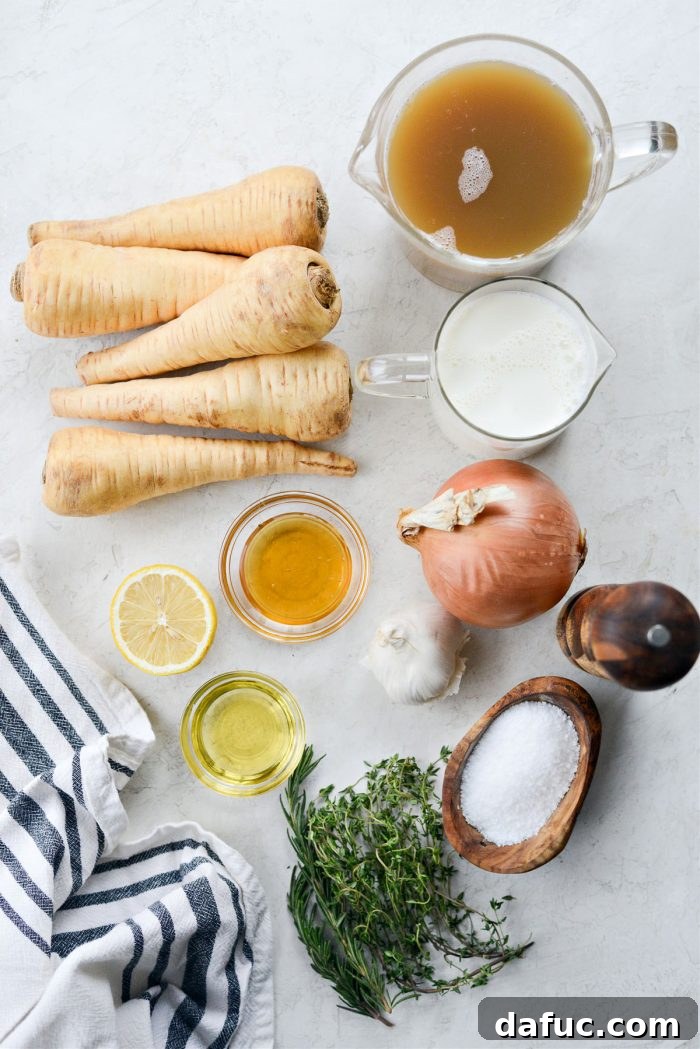 Golden Roasted Parsnip Puree 4 A selection of fresh ingredients for Creamy Roasted Parsnip Soup laid out on a cutting board, including parsnips, garlic, onions, herbs, and oils.