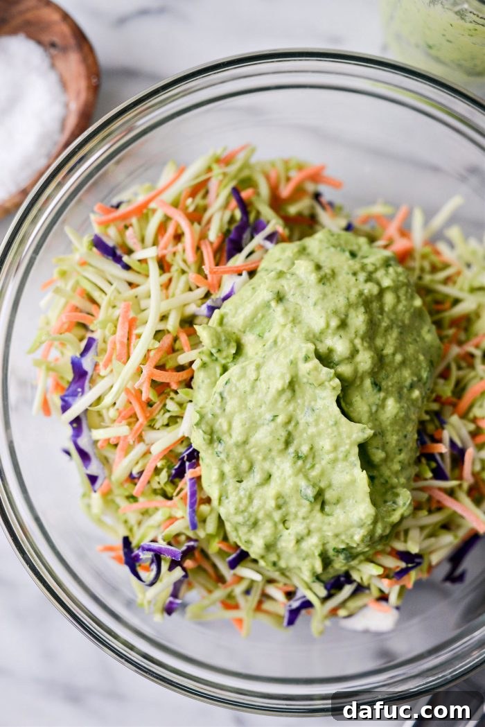 Spicy Salmon Street Tacos 7 Adding avocado dressing to broccoli slaw in a bowl