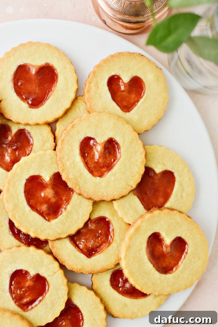Jam Filled Butter Heart Cookies 2 Beautiful Jam Heart Butter Cookies arranged artfully on a white background, showcasing their heart-shaped jam centers.
