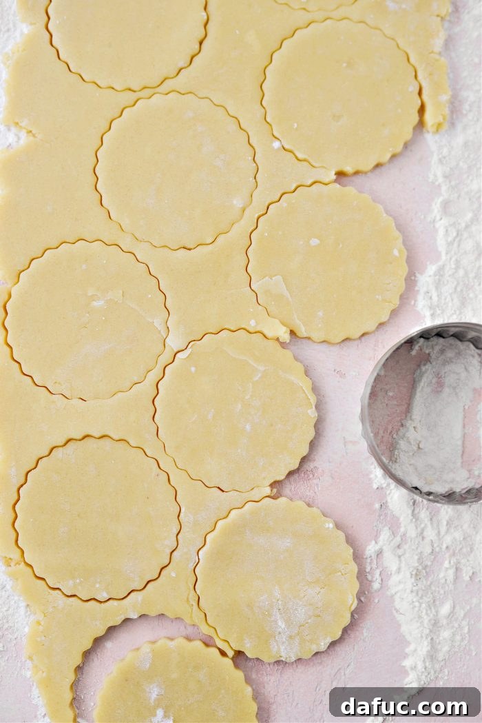 Jam Filled Butter Heart Cookies 11 A round biscuit or cookie cutter stamping out perfect circular cookies from the uniformly rolled-out dough.