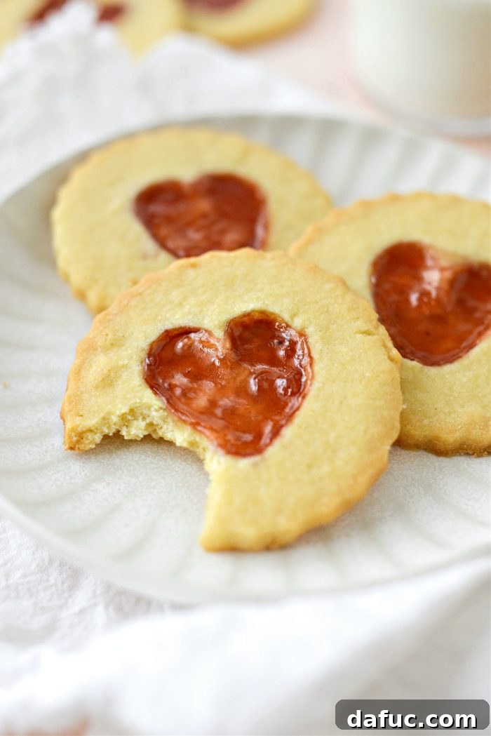 Jam Filled Butter Heart Cookies 21 A close-up shot of two Jam Heart Butter Cookies, perfectly baked and ready to be picked up and enjoyed, highlighting their appealing texture.