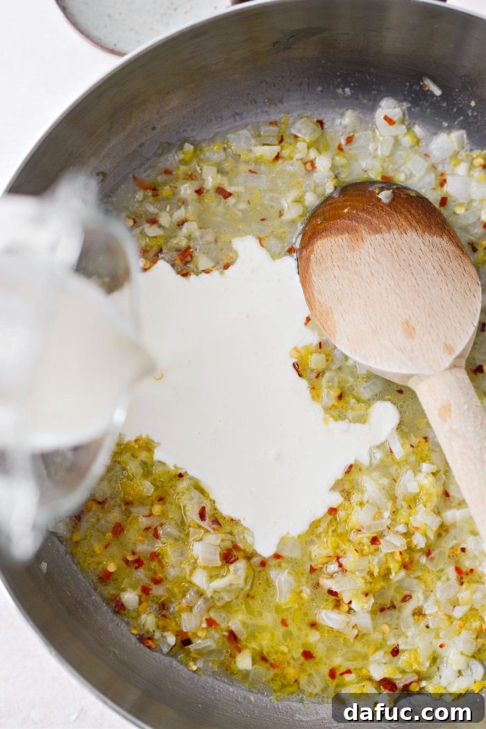 Velvety Lemon Parmesan Pasta 11 Heavy cream being poured into the skillet