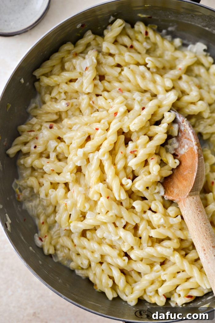 Velvety Lemon Parmesan Pasta 16 Pasta being tossed in the sauce to combine