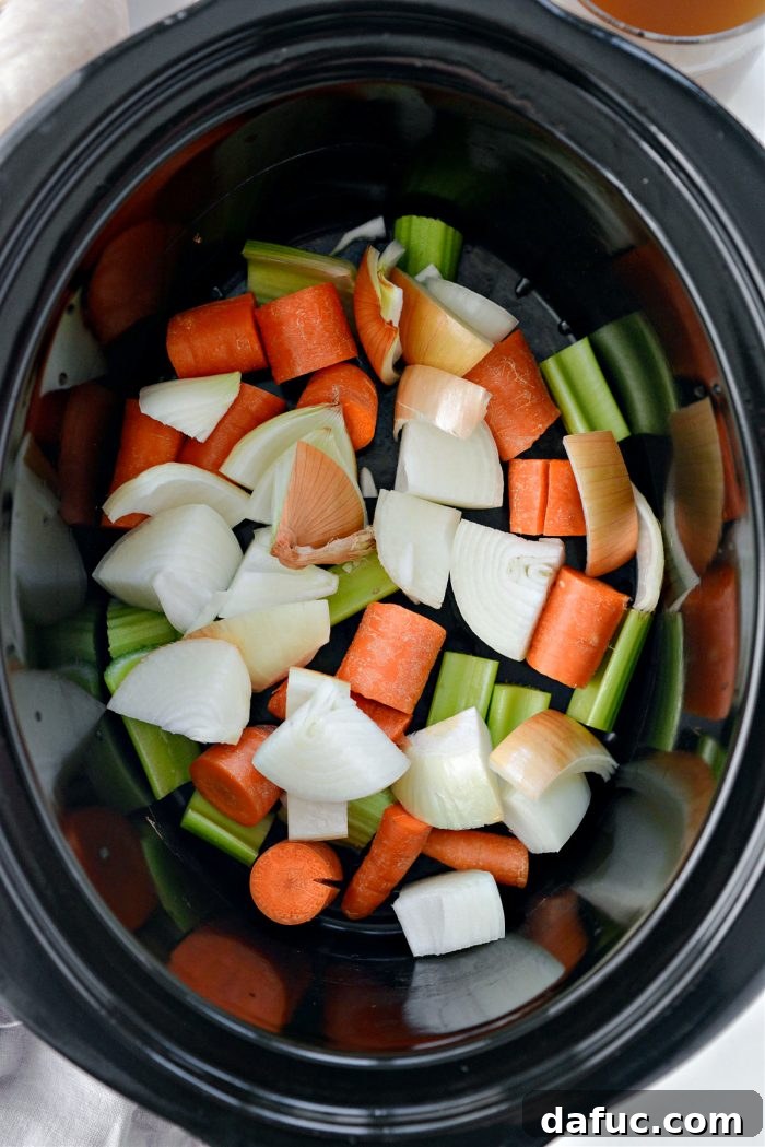 Fall-Off-The-Bone Slow Cooker Chicken 5 Chopped carrots, celery, and onion in a slow cooker